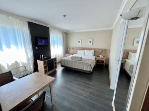 um quarto de hotel com uma cama e uma mesa em Suite executiva reformada dentro do hotel Radisson em São Paulo