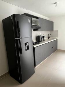 a kitchen with a black refrigerator in a room at Traditional Roomy House in Medellín