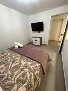 a bedroom with a bed and a flat screen tv at Traditional Roomy House in Medellín