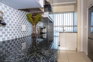 a kitchen with a vase of flowers on a counter at Sea Spray A308 by Host Agents in Bloubergstrand