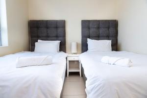 two beds sitting next to each other in a room at Sea Spray A308 by Host Agents in Bloubergstrand
