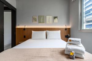 a bedroom with a large white bed and a window at Perfeição no Leblon - Imóvel moderno - AP302 Z1 in Rio de Janeiro