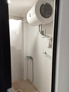a bathroom with a shower with a light on the wall at Ξενώνας museum ισόγειο στο Ελληνικό Ιωαννίνων in Kalentzi +5 photos