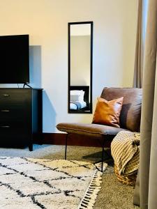 a living room with a couch and a mirror at Allegheny Retreat Close to Downtown in Pittsburgh