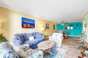 Island Echoes 5L في شاطئ فورت والتون: غرفة معيشة مع أريكة وكراسي زرقاء