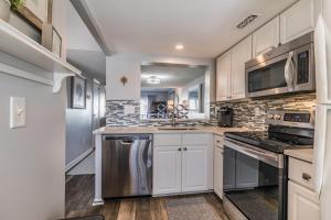 a kitchen with white cabinets and stainless steel appliances at NEW LISTING! Ocean and Pool Views on Harbor Island - Short Walk to Pool and Beach in Harbor Island