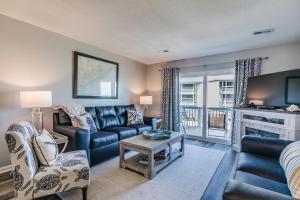 a living room with a couch and a tv at NEW LISTING! Ocean and Pool Views on Harbor Island - Short Walk to Pool and Beach in Harbor Island