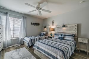 a bedroom with two beds and a ceiling fan at NEW LISTING! Ocean and Pool Views on Harbor Island - Short Walk to Pool and Beach in Harbor Island +33 photos