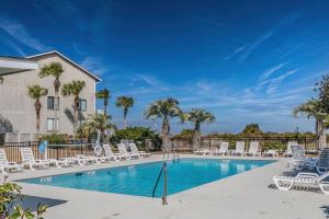 a swimming pool with lounge chairs and palm trees at NEW LISTING! Ocean and Pool Views on Harbor Island - Short Walk to Pool and Beach in Harbor Island
