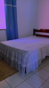 uma cama num quarto com uma cortina azul em Onde a paz prevalece em Angra dos Reis