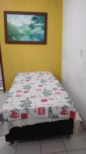 uma cama num quarto com um cobertor em Onde a paz prevalece em Angra dos Reis