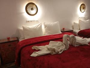 a hotel room with two beds with towels on them at Riad Papadou in Marrakesh