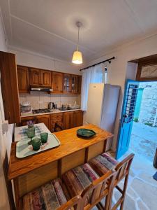 a kitchen with a wooden table and a refrigerator at Cozy Traditional 1 Bedroom Home Omodos Village in Omodos