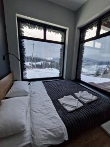 a bedroom with a large bed with two towels on it at Chilloutzonе - Будинок з безкоштовним джакузі та кінотеатром in Slavske