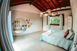 a bedroom with a bed and a large mirror at Paradise Bonito: mansão com piscina in Bonito