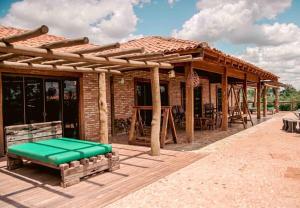 a wooden pavilion with a green bench on a wooden deck at Paradise Bonito: mansão com piscina in Bonito