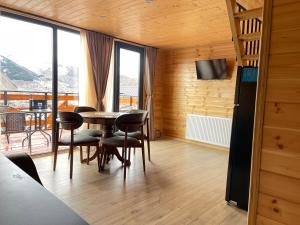 Cette chambre dispose d'une table, de chaises et d'un balcon. dans l'établissement Cozy Home Kazbegi, à Kazbegi