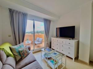 a living room with a couch and a tv at SR Santa Maria Golf Marbella with Sea Views in Marbella