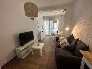 a living room with a couch and a flat screen tv at Rosario Apartament 4Px2b Wifi in Valencia