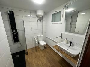 a bathroom with a sink and a toilet and a mirror at Rosario Apartament 4Px2b Wifi in Valencia