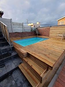 a wooden deck with a swimming pool on a rooftop at Spindrift Seaside Accommodation in Wilderness
