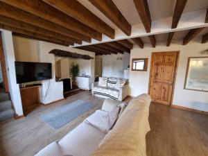 a living room with a couch and a tv at Cosy Cottage in Edern, Morfa Nefyn, Golf, Near Ty Coch in Ederyn