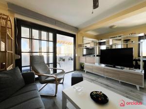 a living room with a couch and a tv at Bello Amanecer en La Concha in Oropesa del Mar