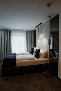 ein Schlafzimmer mit einem großen Bett und einem Fenster in der Unterkunft The Place Boutique & Design Hotel Flachau in Flachau