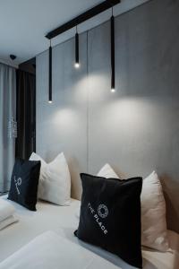 Schlafzimmer mit einem Bett mit schwarzen und weißen Kissen in der Unterkunft The Place Boutique & Design Hotel Flachau in Flachau