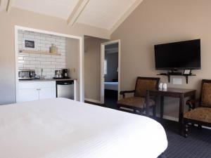 um quarto com uma cama e 2 cadeiras e uma cozinha em Golden Haven Hot Springs em Calistoga