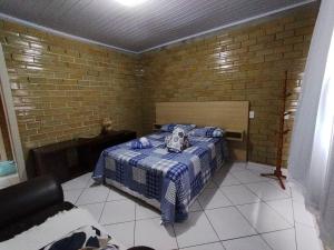 a bedroom with a bed in a brick wall at CASA DE PRAIA ILHA in Araranguá