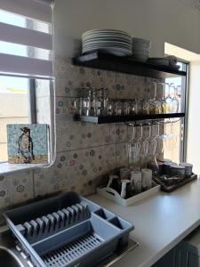 Spindrift Seaside Accommodation في وايلدرنيس: مطبخ مع مغسلة وكاونتر مع صحون