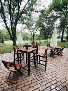 un patio con mesas, sillas y sombrillas blancas en That 70s House at Hidden Creek Estates, en Roscoe