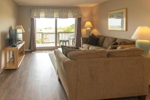 Una sala de estar con un sofá y un televisor. en NEW LISTING Ocean Front 1 Bedroom - New Decks and Pool Access, en Harbor Island