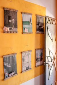a wall with framed pictures on a wall at Ayour Hostel in Sidi Kaouki