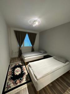 a bedroom with two beds and a rug at Cozy and modern apartment with lakeside view in Rovaniemi