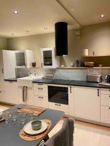 a kitchen with white cabinets and a table with a plate at Suites du trèfle in Colmar +9 photos