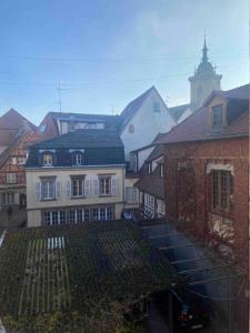 a group of buildings with a church in the background at Suites du trèfle in Colmar
