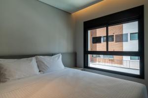 a bedroom with a bed and a window at EZ Moema Hotel in São Paulo