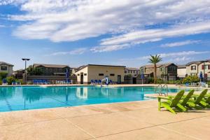uma piscina com espreguiçadeiras verdes e condomínios em The Spotless 2 Story em Phoenix