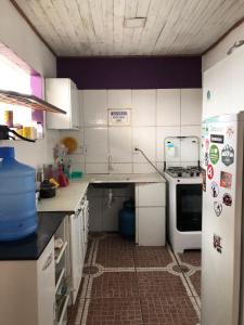 een keuken met witte kasten en een koelkast bij Hostel Solar in Mucugê