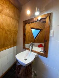 W łazience znajduje się umywalka i lustro. w obiekcie Domo Rústico w mieście Ranco