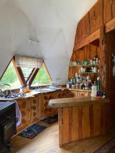 uma cozinha com paredes de madeira e uma mesa num quarto em Domo Rústico em Ranco