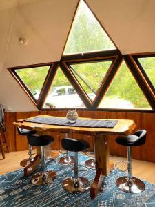 Habitación con mesa y taburetes frente a una ventana en Domo Rústico, en Ranco