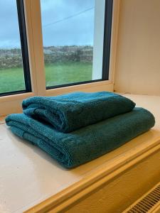 a pile of blankets sitting on a window sill at Killawalla Cottage, Westport. in Westport