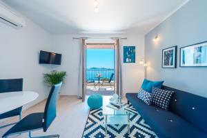 Apartments Villa Made 4U في مْليني: غرفة معيشة مع أريكة زرقاء وطاولة