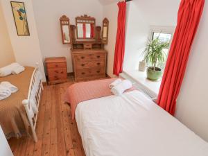 a bedroom with two beds and a window at Kernyk in Helston