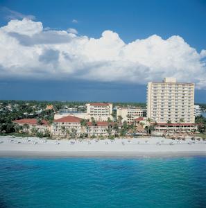 a view of a beach with buildings and birds on it at La Playa Beach & Golf Resort, a Noble House Resort in Naples