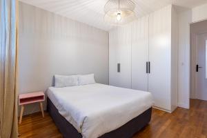een slaapkamer met een wit bed en een witte kast bij Smart Inn La Rochette 25mn Paris in La Rochette