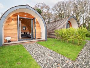 a circular house with a large door in a yard at Vic in St Austell